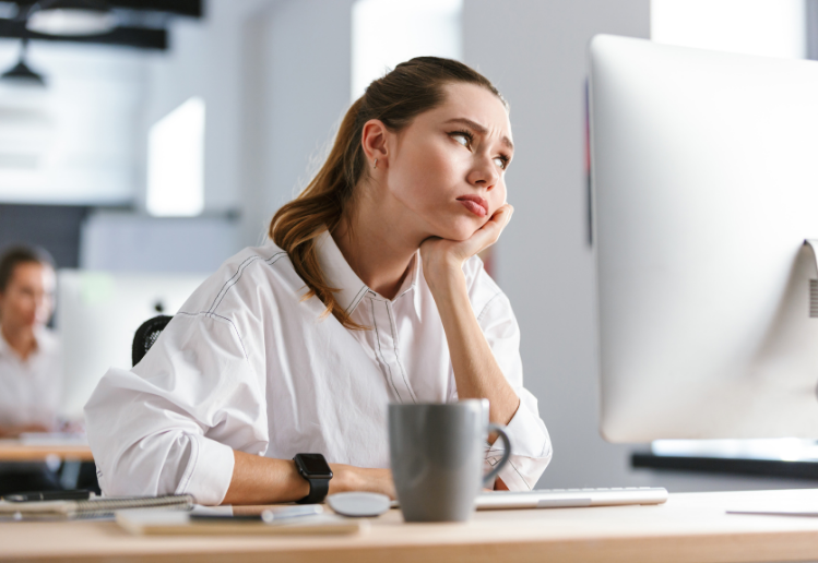 how to market boring products -Woman looking bored while sat at her computer